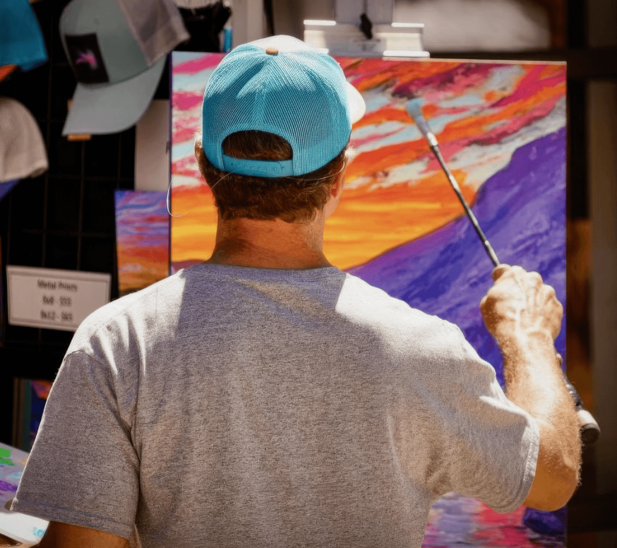 Zach Otte painting a colorful landscape at an easel